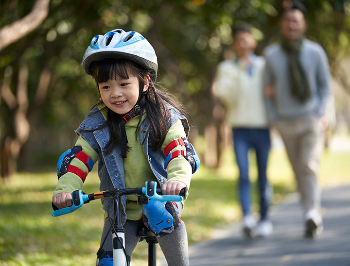 Image of young family walking in an open green space